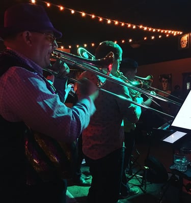 a man playing trombone in river city riot brass band, mardi gras, new orleans music