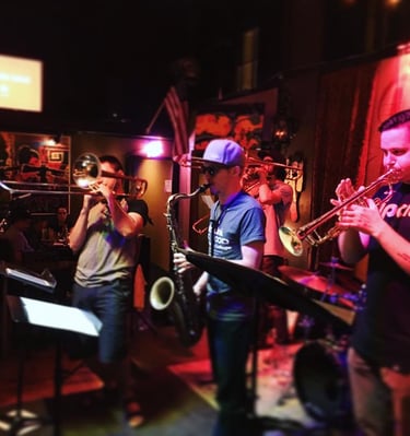 a band playing instruments in a brass band, portland oregon, mardi gras, new orleans music