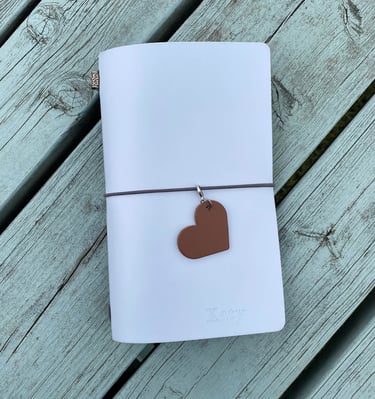 a traveller style journal with a heart shaped leather journal