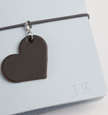 a heart shaped leather tag with a leather heart charm