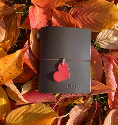 a leather journal with a heart shaped leather heart on it