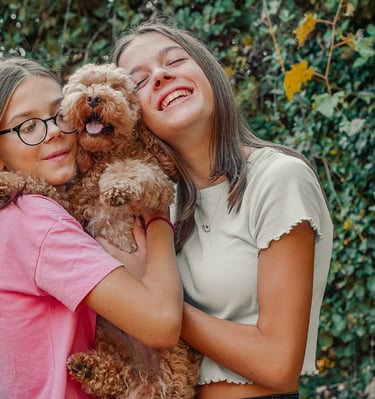 ritratto di bambine sorridenti col proprio cane in natura