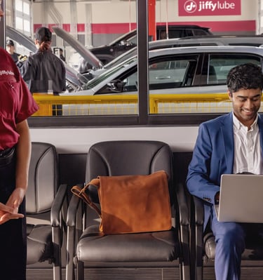 Jiffy Lube employee standing and observing the service area.