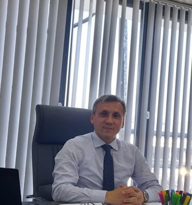 a man in a suit and tie sitting at a desk