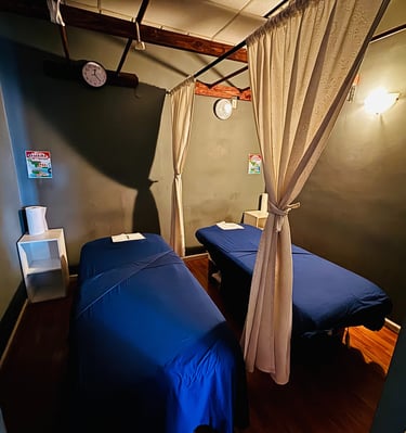 a couple of beds in a room with a curtain