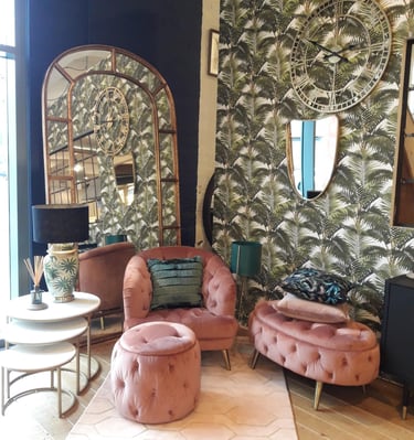 a living room with a pink arm chair and a mirror