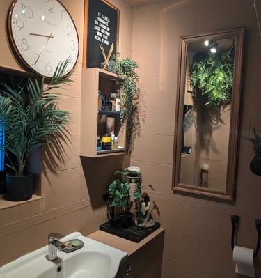 a bathroom with a clock, mirror and plants ideas
