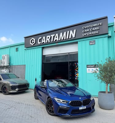 A blue BMW M8 convertible parked outside Cartamin car care workshop for professional detailing and upgrades.