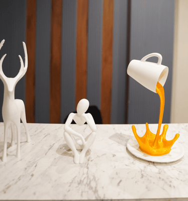 a person pouring orange juice into a cupcake