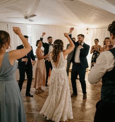 Family and friends dancing joyfully during a colorful sangeet ceremony.