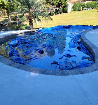 a pool with a blue tarp and a blue tarp