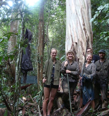 a group of people standing in a forest during the jungle expedition