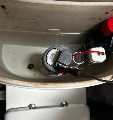 Internal view of a toilet cistern tank showing the Roca flush valve and dual flush mechanism.