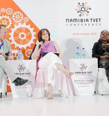 Three people on stage at a conference