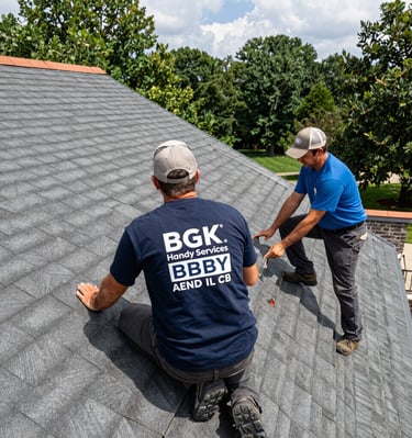 Professional contractors from BGK Handy Services performing a roof inspection and shingle repair on a residential home.