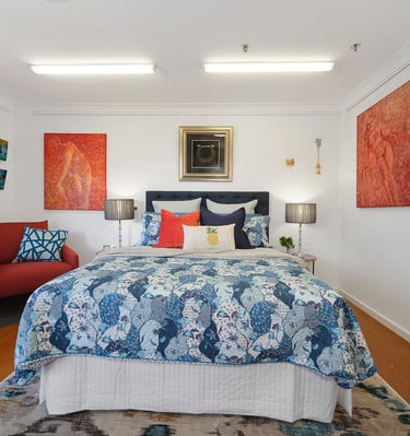 Cozy bedroom at Marche Home Stay with a queen bed, colourful artwork, soft lighting, and a welcoming, homely atmosphere.