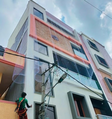 Technician carefully installing pigeon nets on a residential apartment balcony.