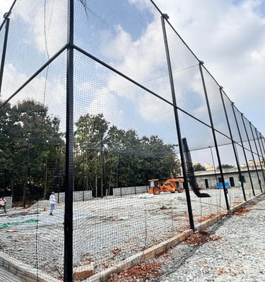Wide shot of a rooftop safety net installation protecting a busy construction site in Ahmedabad