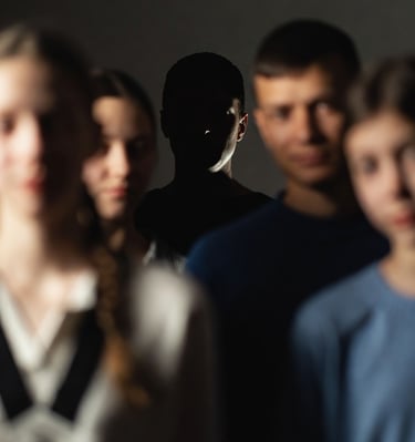 A family portrait where everyone is sharply lit except one figure slightly pushed into shadow