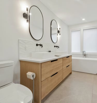 Salle de bain sur mesure avec meuble double vasque en bois clair et baignoire îlot conçue par Baïa Home à Caen