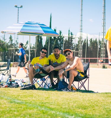 Fotografía de jugadores descansando en un campo de césped en un torneo de ultimate frisbee