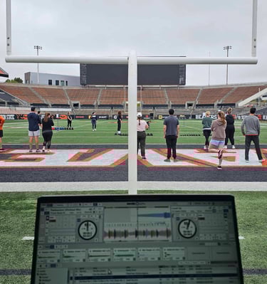 a DJ's laptop setup on the football field at Reeser Station in Oregon