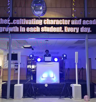 DJ Aaron Harris performing on stage at Silverton High School in the commons area