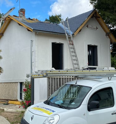 Fourgon d'un entrepreneur en toiture professionnel garé devant une maison en cours de réparation d'u