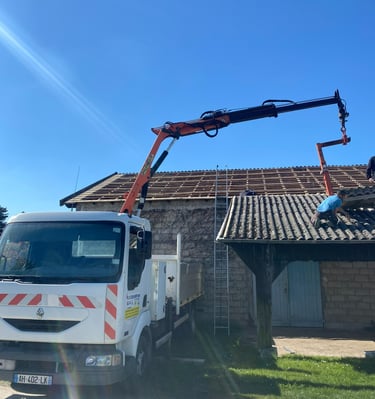 Une grue mobile levant des matériaux de toiture pour la réparation d'un toit sur un bâtiment en pier