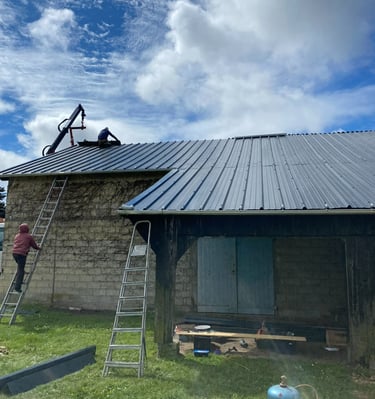Des entrepreneurs professionnels installant un nouveau toit en métal à joint debout de couleur gris 