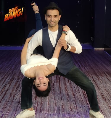 Professional dance partners performing an acrobatic dip pose in a studio for Bang Bang choreography.