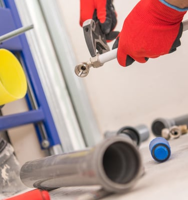 Sanitärinstallateur montiert Rohrleitungen und Anschlüsse im Badezimmer