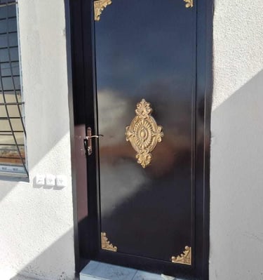 باب حديد خارجي أسود بتفاصيل زخرفية فاخرة، تصميم مخصص لمداخل المنازل في الرياض.