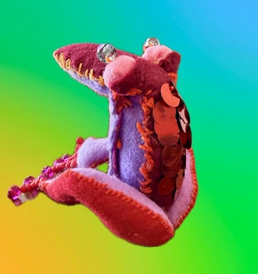 bird-like alien critter. Berry/lavender color way with beaded eyes and toes