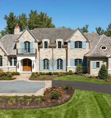 Stone French country custom home with shingle roof in western Chicago suburbs