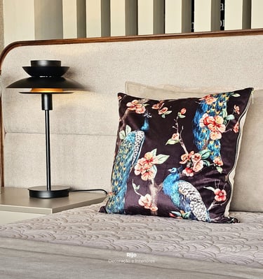 Elegant bedroom decor featuring a black metal lamp and peacock print decorative pillow.