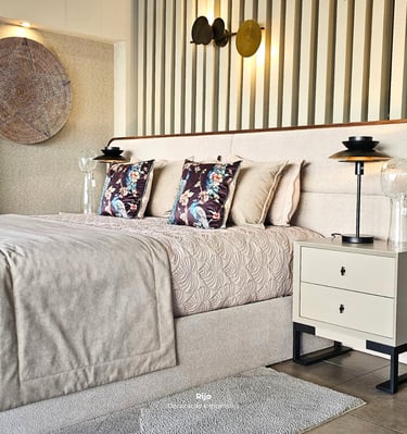 Modern luxury bedroom featuring a beige upholstered bed, floral pillows, and minimalist nightstands with elegant lighting.