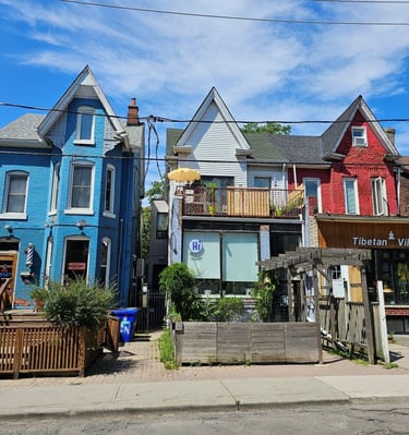 Colorful Victorian row houses featuring local businesses and shops in vibrant Toronto neighborhood.