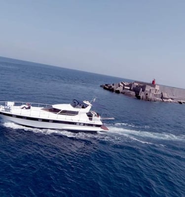 a boat in the water with a lighthouse in the background