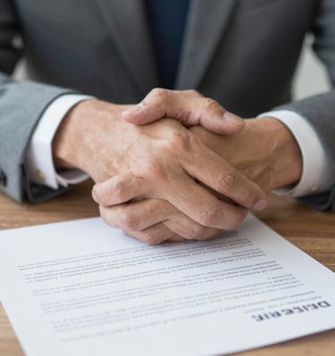 A close-up of hands shaking over a property contract, symbolizing fast, fee-free sales.