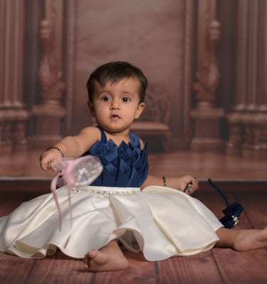 Baby girl in satin party dress sitting for a professional studio photoshoot. Wonderpose photography