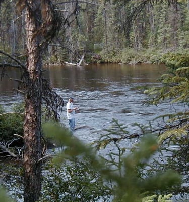 a man standing in a river with a fly fishing