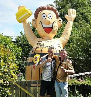 Opblaasbare Abraham in biervat in tuin met de jarige op de voorgrond