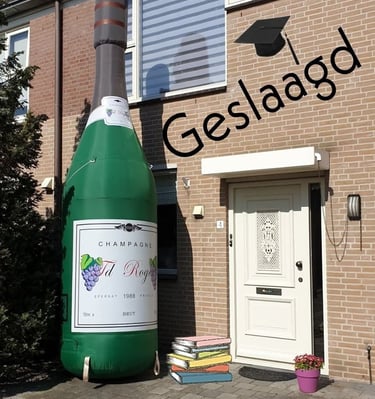 Groene opblaasbare champagne fles aan de voorkant van een huis voor een geslaagde