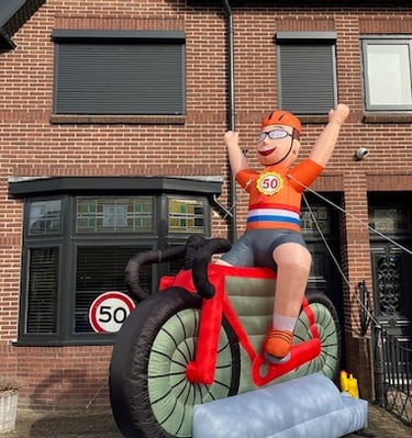 Oblaasbare wielrenner met oranje shirt en Nederlandse vlag zitten op een rode racefiets