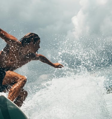 a man with long hair riding a surfboard in the ocean