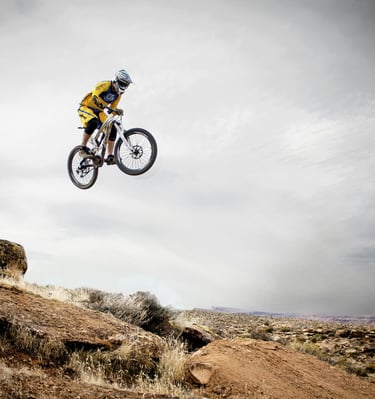 a person jumping a motocross bike in the air in the Utah mountains