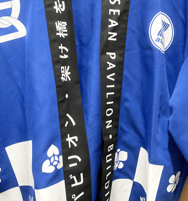 a blue jacket with a black ribbon around it