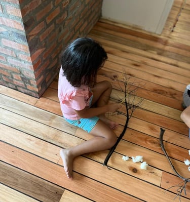 Criança brincando com elementos naturais.