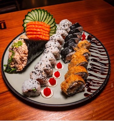 a plate of sushi rolls with sauce and sauce